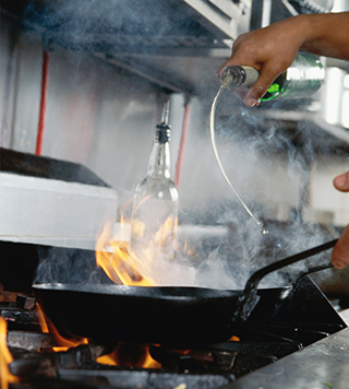 Cooking with flame under kitchen exhaust hood