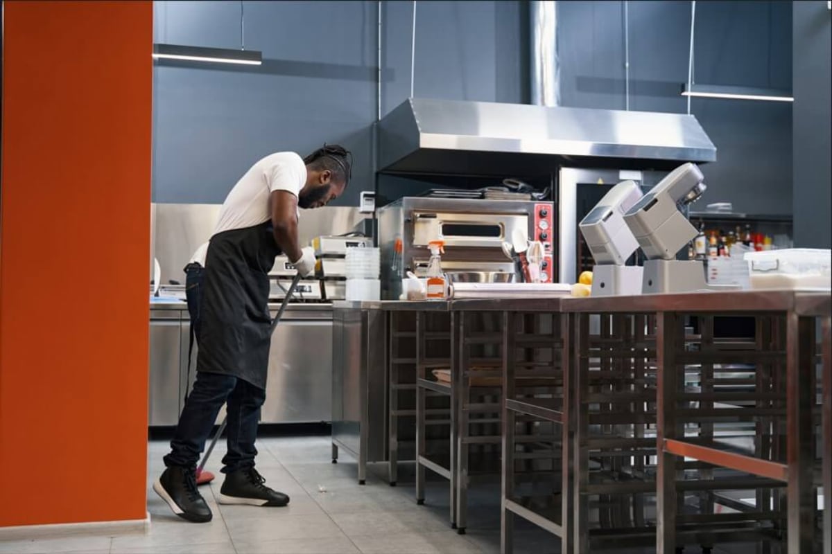 Adult chef cleaning work place in restaurant